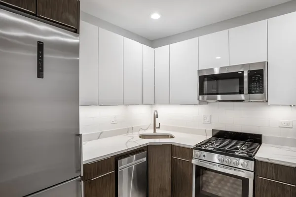 a kitchen with stainless steel appliances a sink dishwasher stove and microwave with wooden cabinets