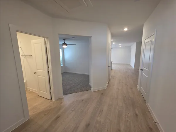 a view of empty room with wooden floor