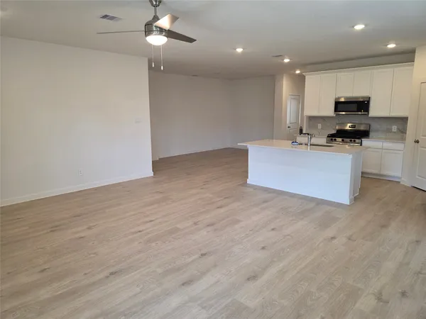 a view of kitchen with microwave stove top oven and cabinets