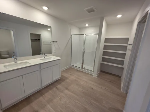 a spacious bathroom with a double vanity sink and a mirror
