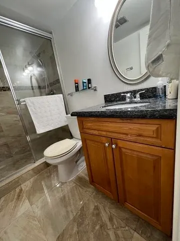 a bathroom with a toilet a sink and mirror