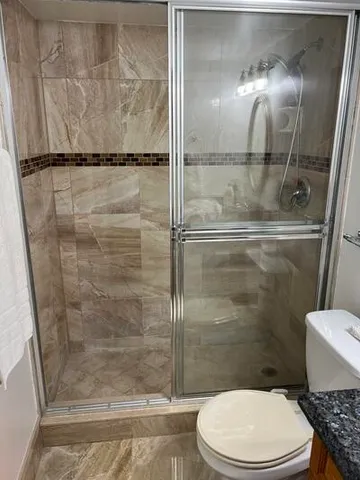 a bathroom with a toilet and a shower