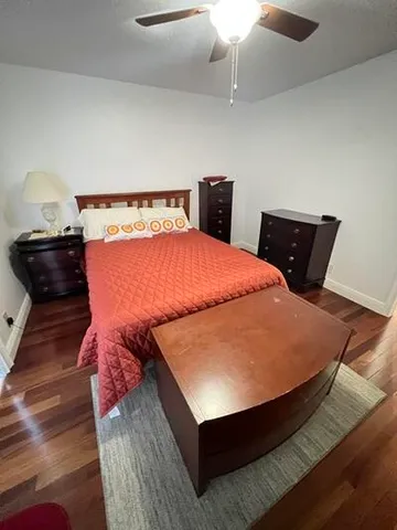 a bed sitting in a bedroom and wooden floor