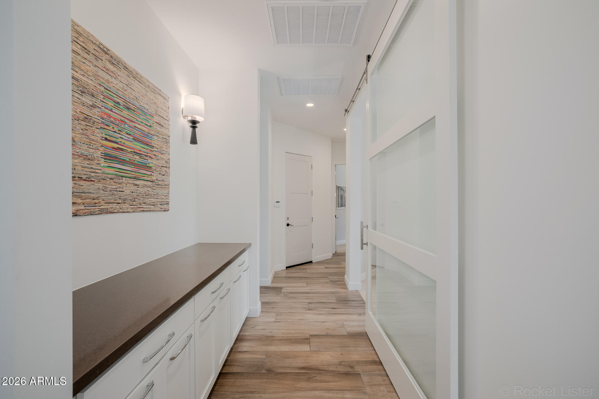 2665 East Hummingbird Way Gilbert, AZ 85297 - Photo 53 of 100 a hallway with white doors wooden floor and staircase