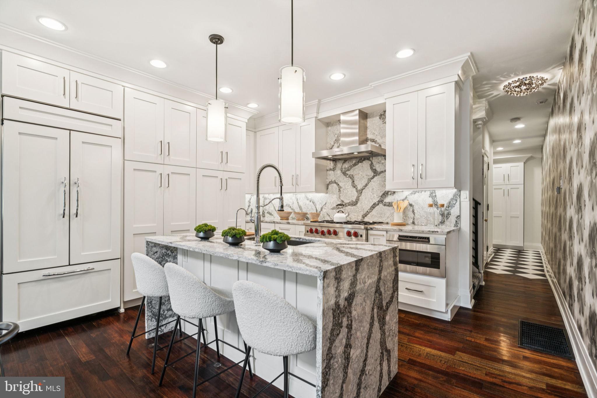 2109 Locust Street Philadelphia, PA 19103 - Photo 4 of 38 a kitchen with stainless steel appliances kitchen island a table chairs in it and wooden floors