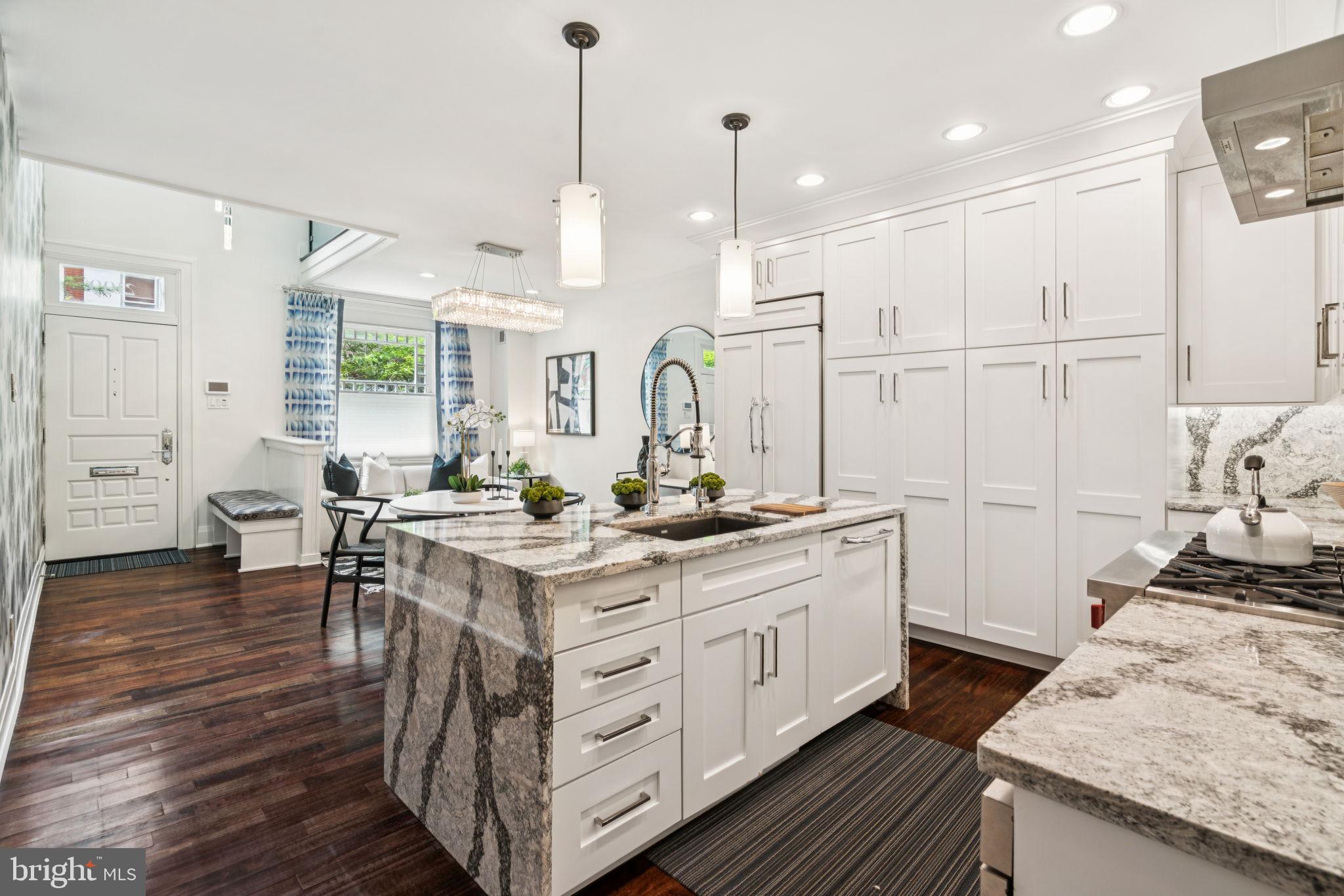 2109 Locust Street Philadelphia, PA 19103 - Photo 6 of 38 a large kitchen with kitchen island a stove a sink a dining table and chairs
