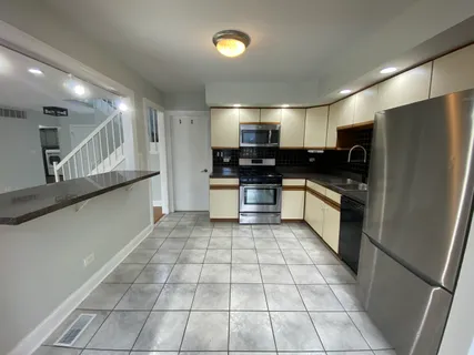 a large kitchen with a large counter top and stainless steel appliances