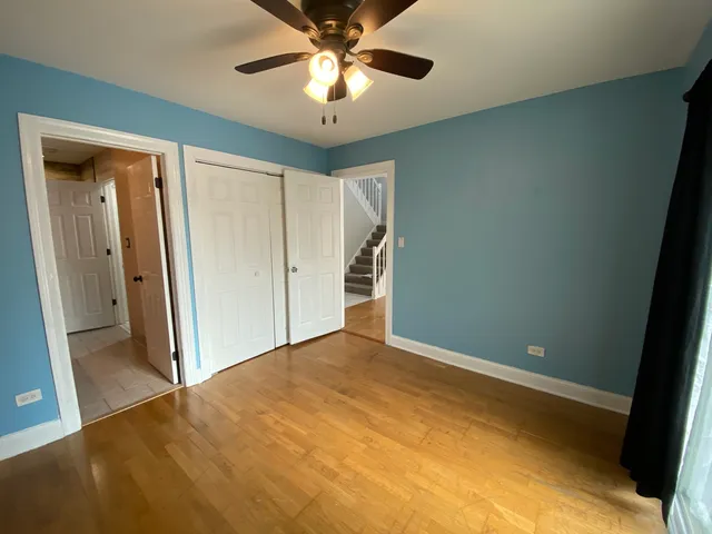 a view of an empty room and chandelier fan