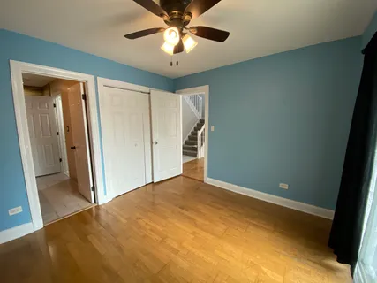 a view of an empty room and chandelier fan