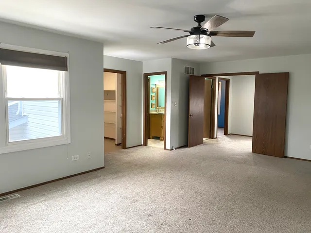 a view of a livingroom with a ceiling fan and window