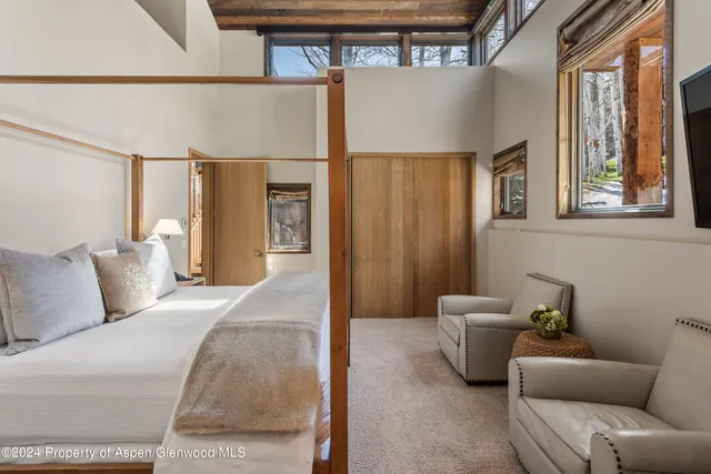 a bedroom with a bed couch and a flat tv screen