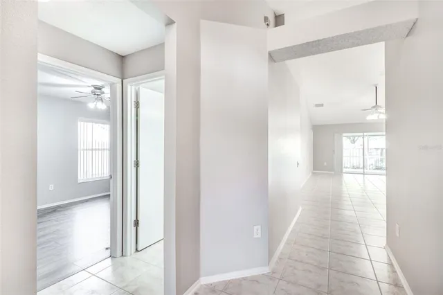 a view of an empty room with wooden floor and a chandelier