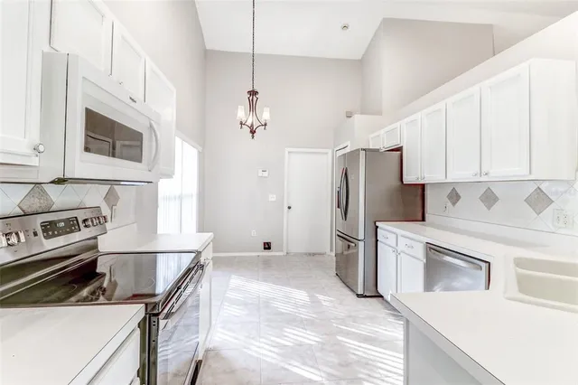 a kitchen with stainless steel appliances granite countertop a stove a refrigerator and a microwave