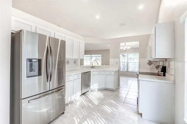 a kitchen with a refrigerator a sink and cabinets