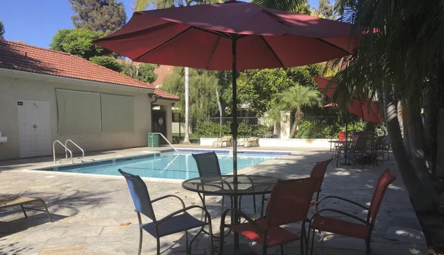 a view of patio with table and chairs under an umbrella