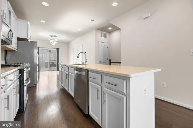 a kitchen with stainless steel appliances a refrigerator sink and cabinets