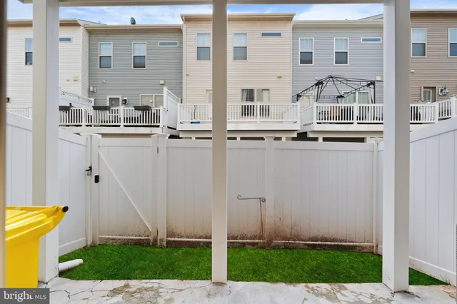 a view of a white building with many windows and yard