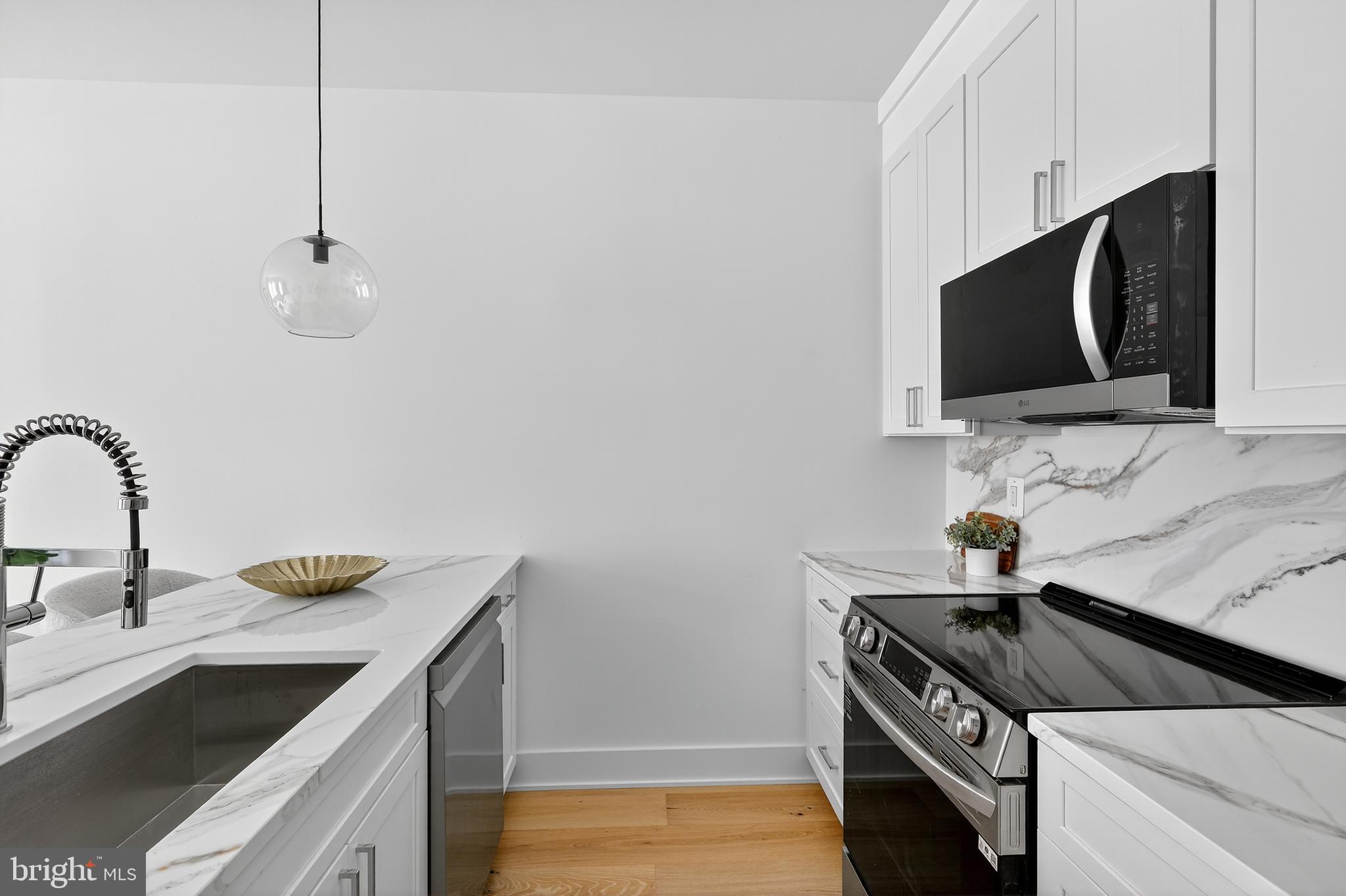 828 21st Street Northeast, Unit 1 Washington, DC 20002 - Photo 11 of 30 a kitchen with stainless steel appliances a sink a stove a microwave and cabinets
