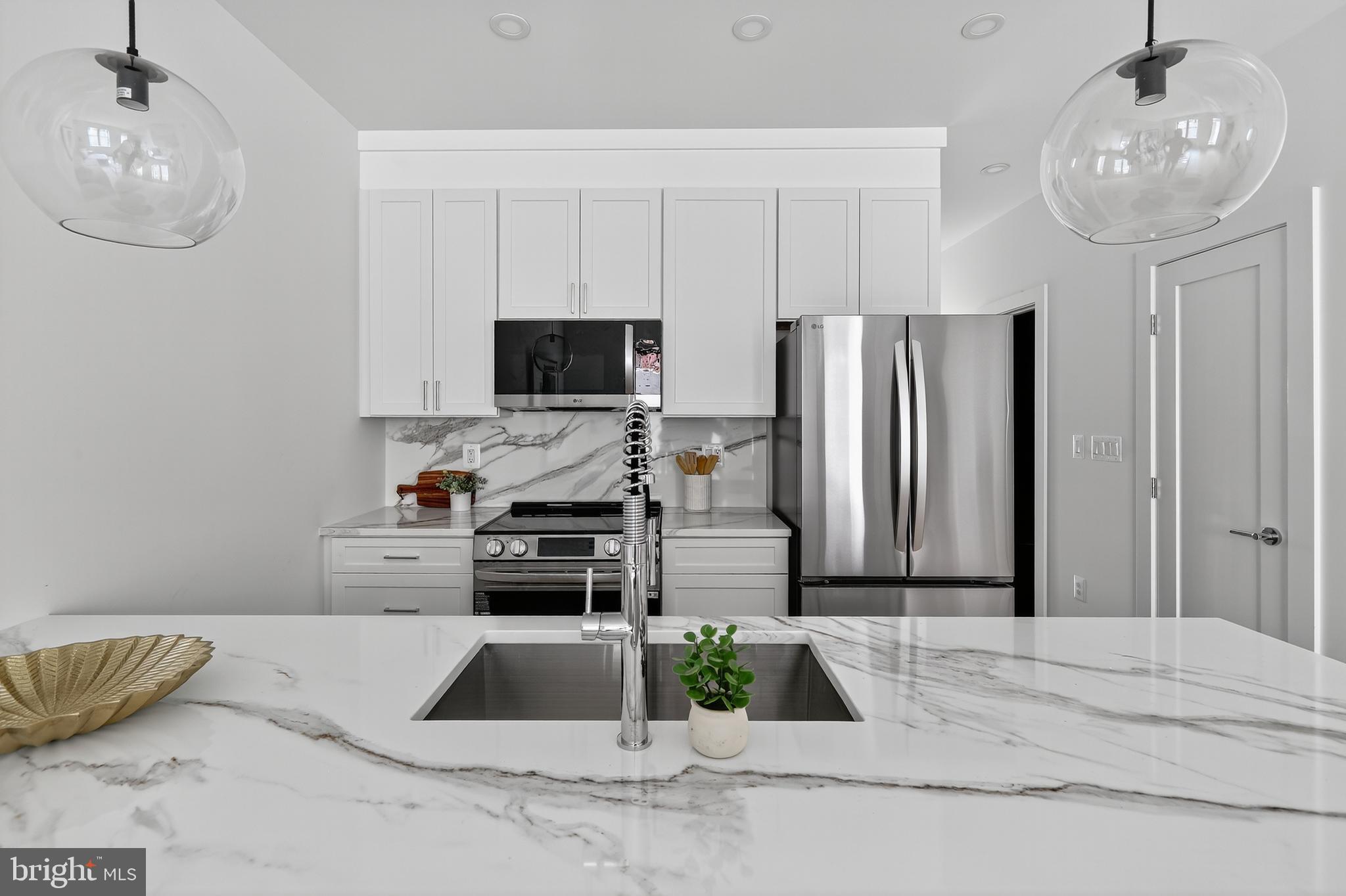 828 21st Street Northeast, Unit 1 Washington, DC 20002 - Photo 12 of 30 a kitchen with stainless steel appliances kitchen island granite countertop a refrigerator and a stove top oven
