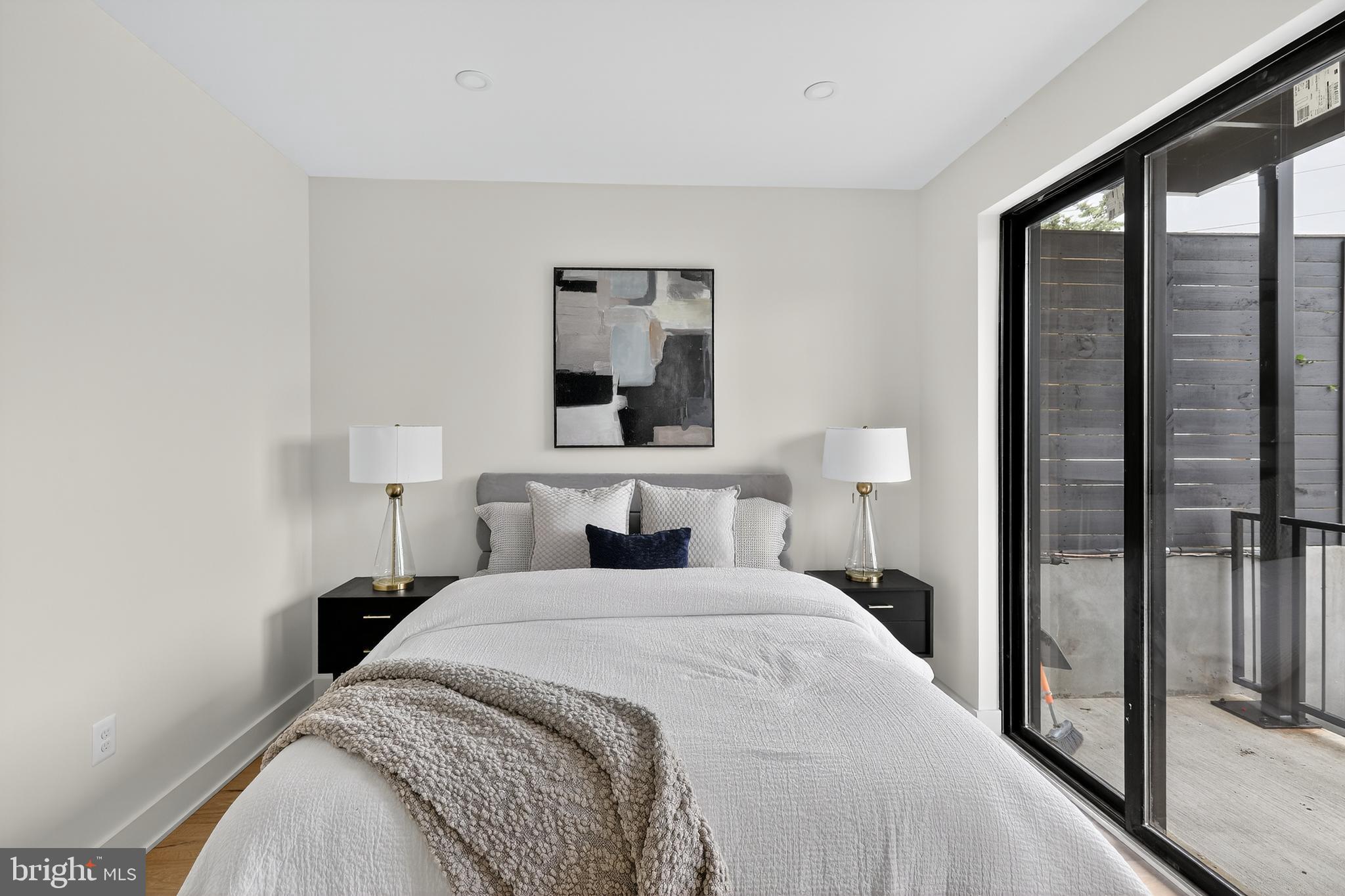 828 21st Street Northeast, Unit 1 Washington, DC 20002 - Photo 20 of 30 a bedroom with a large bed and a lamp