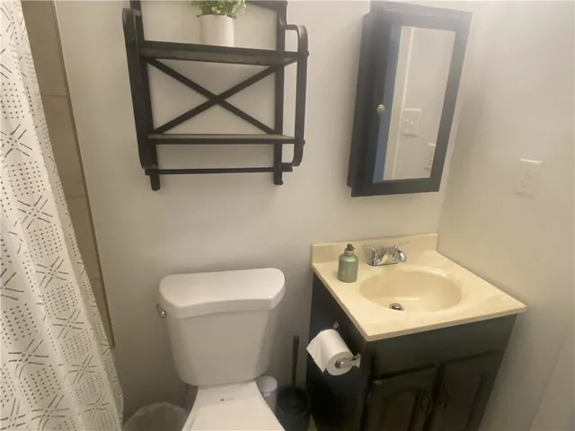 a bathroom with a toilet sink and mirror