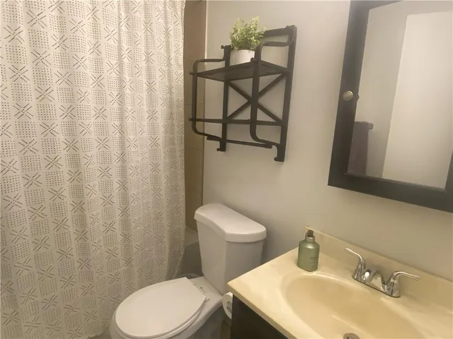 a bathroom with a sink a toilet and shower curtain