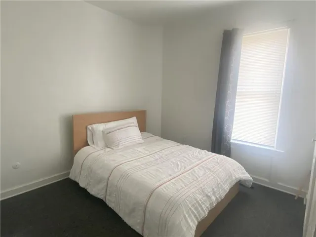 a large bed sitting in a bedroom next to a window