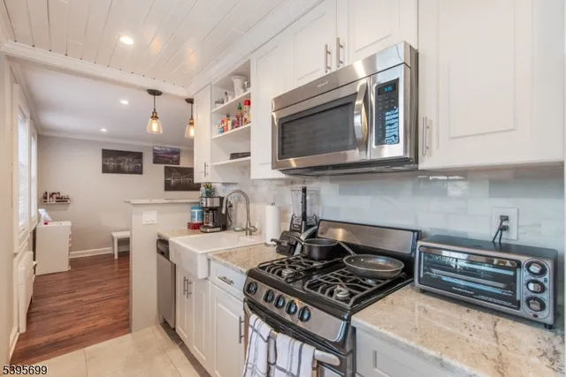 a kitchen with stainless steel appliances a stove a microwave a sink and cabinets