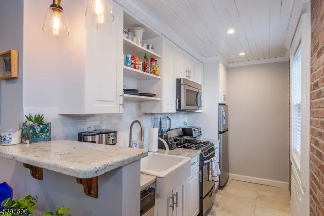 a kitchen with stainless steel appliances granite countertop a sink stove and cabinets