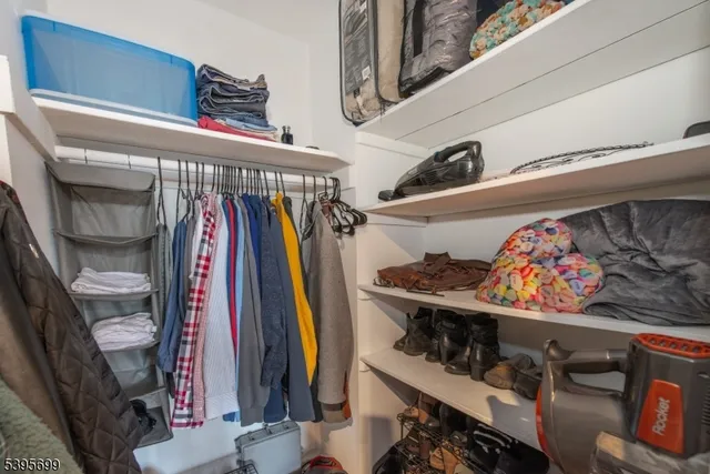 a view of walk in closet with clothes