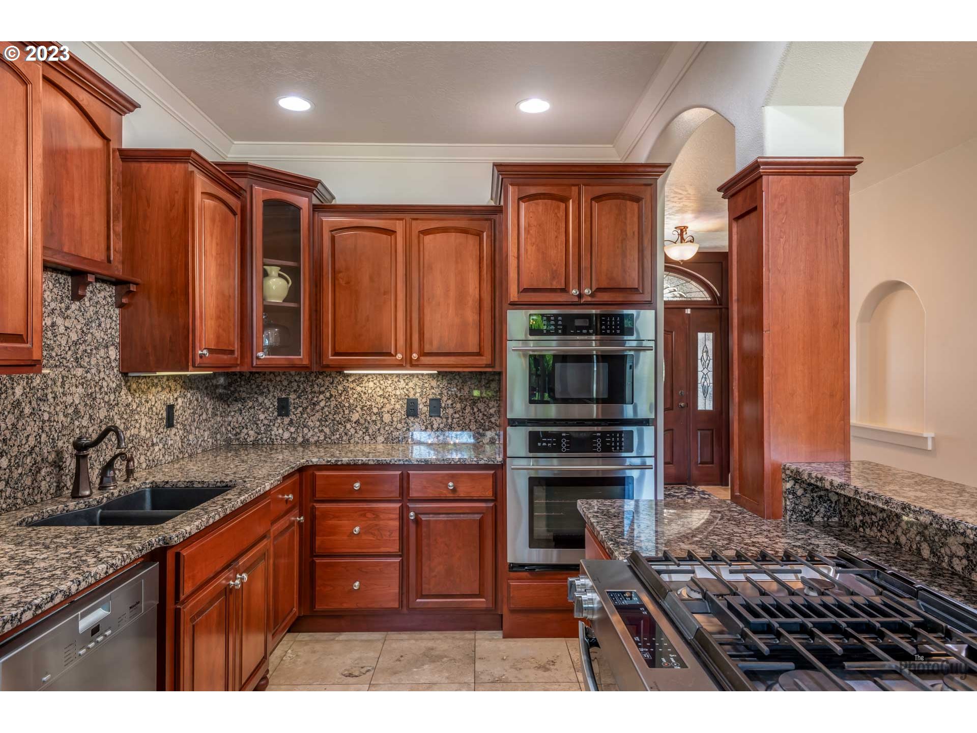 6099 Graystone Loop Springfield, OR 97478 - Photo 12 of 48 a kitchen with stainless steel appliances granite countertop a stove a sink and a microwave