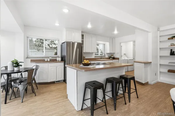 a kitchen with refrigerator a sink and chairs