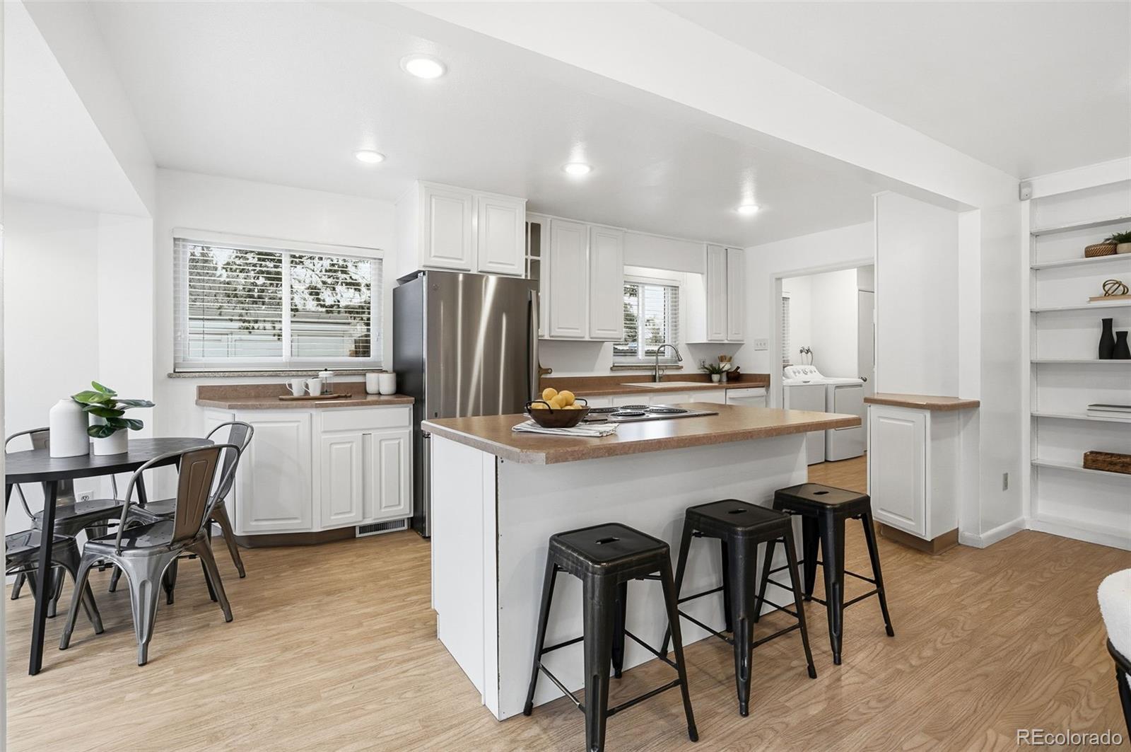 800 East Pinewood Avenue Littleton, CO 80121 - Photo 12 of 42 a kitchen with refrigerator a sink and chairs