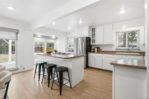 a kitchen with white cabinets and refrigerator