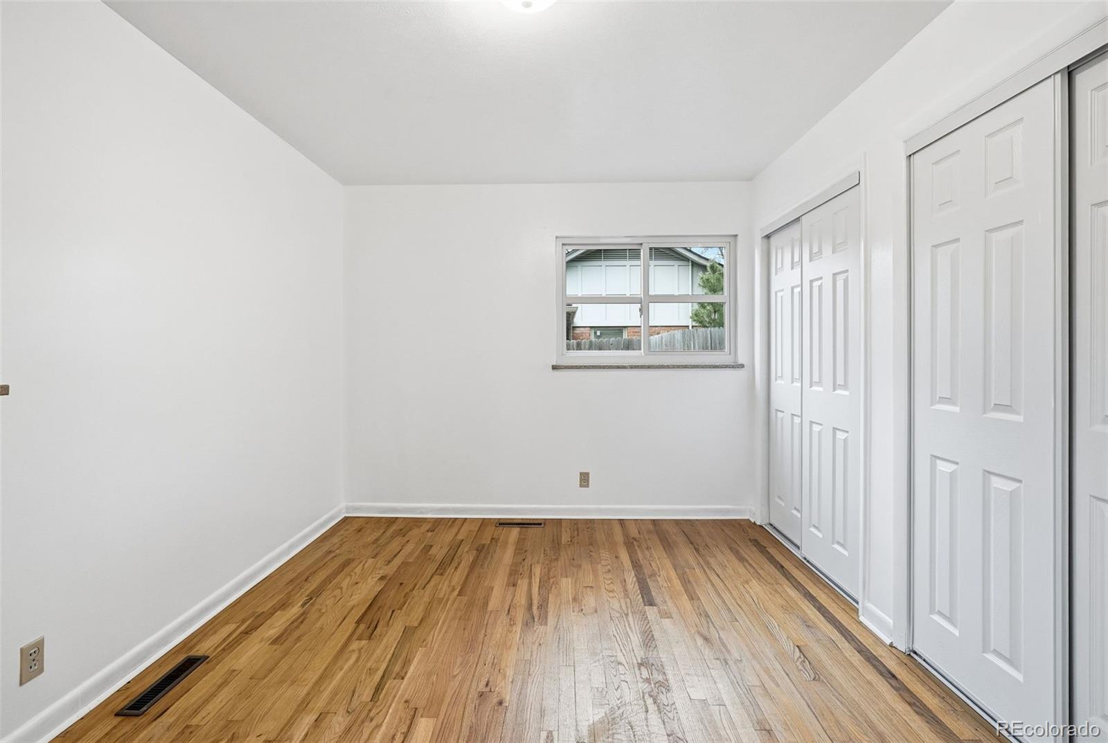 800 East Pinewood Avenue Littleton, CO 80121 - Photo 27 of 42 an empty room with wooden floor and windows