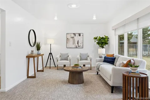 a living room with furniture a window and a potted plant