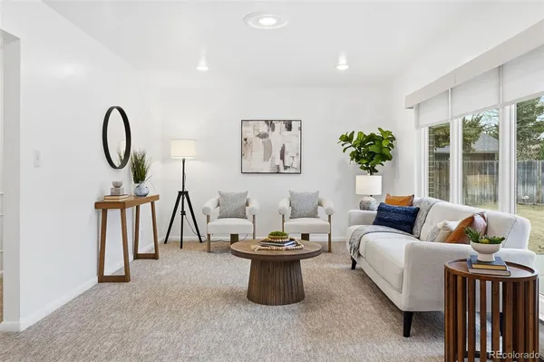 a living room with furniture a window and a potted plant