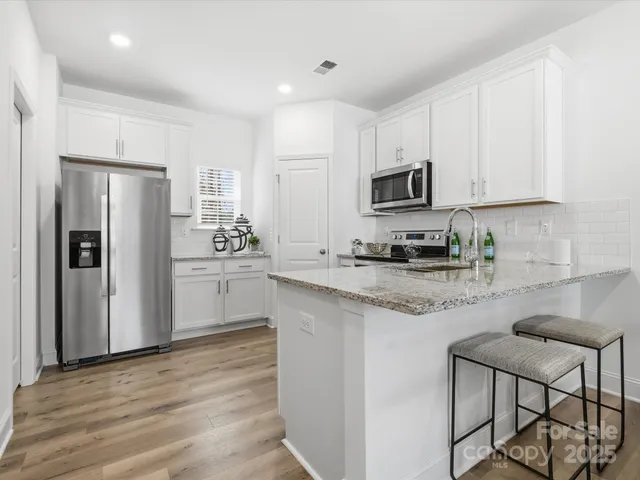 a kitchen with stainless steel appliances granite countertop a refrigerator stove microwave and sink