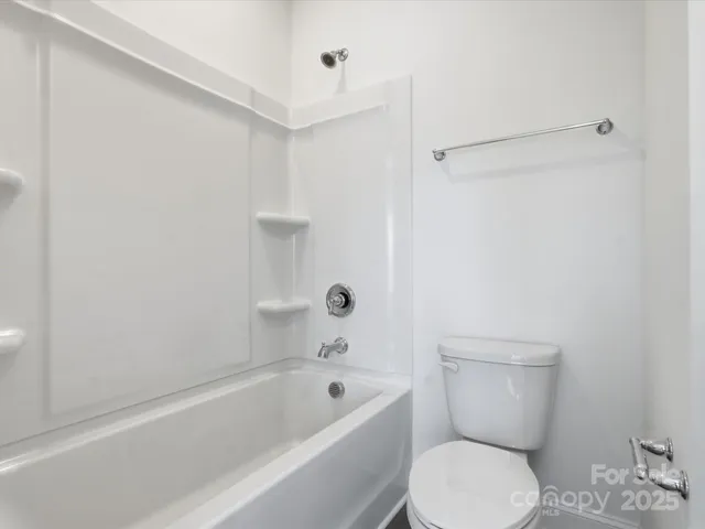 a white toilet sitting next to a bath tub