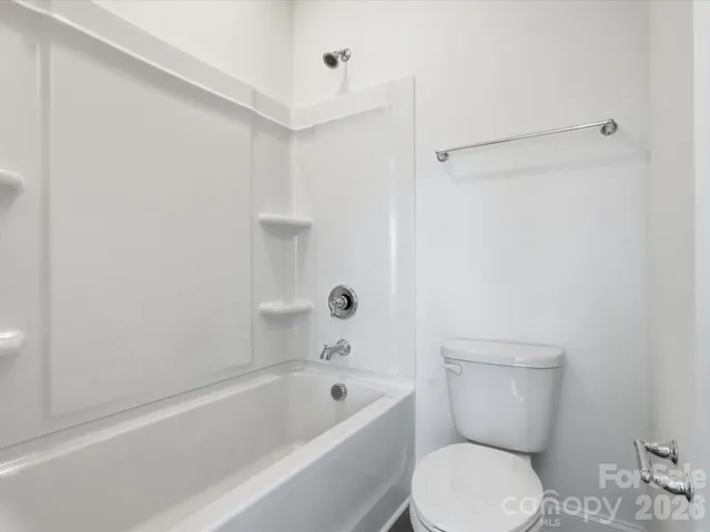 a bathroom with a toilet sink vanity and mirror