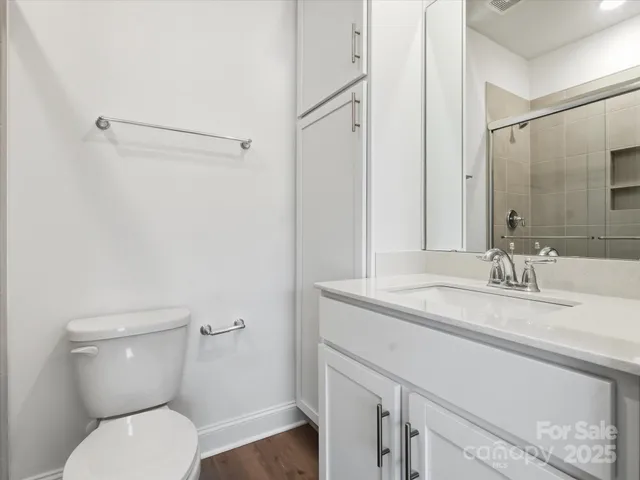a bathroom with a granite countertop toilet sink and mirror