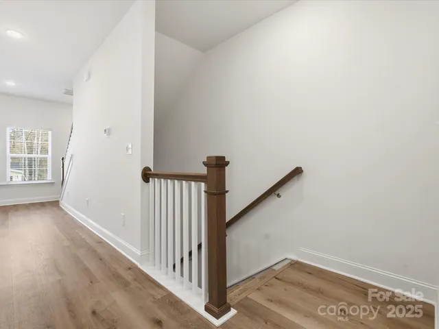 a view of a hallway with entryway with wooden floor