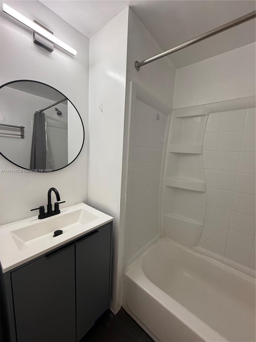 233 80th Street, Unit 1 Miami Beach, FL 33141 - Photo 14 of 24 a bathroom with a sink and a mirror