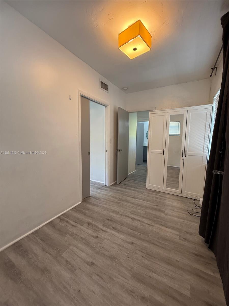 233 80th Street, Unit 1 Miami Beach, FL 33141 - Photo 16 of 24 wooden floor in an empty room with a window