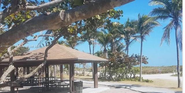 233 80th Street, Unit 1 Miami Beach, FL 33141 - Photo 20 of 24 a backyard of a house with table and chairs under an umbrella