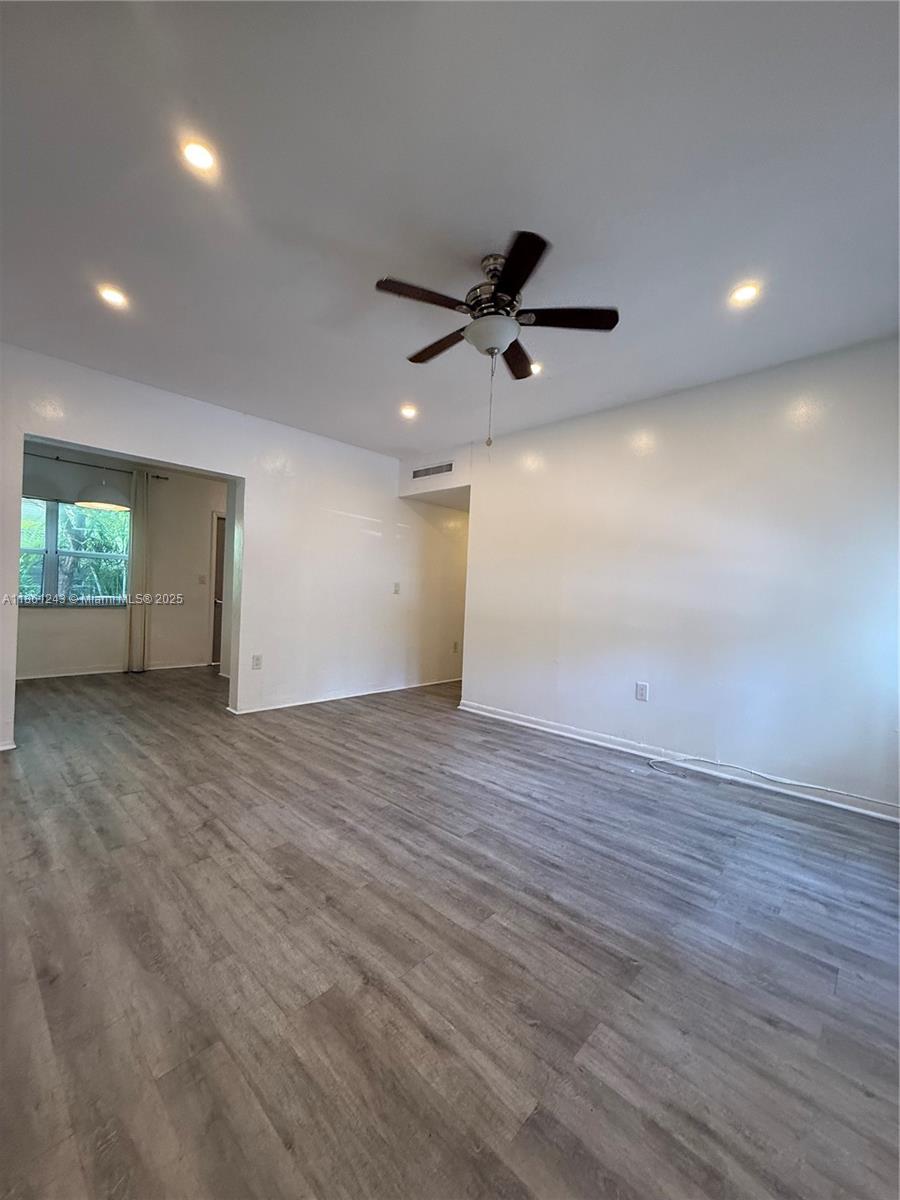 233 80th Street, Unit 1 Miami Beach, FL 33141 - Photo 4 of 24 an empty room with wooden floor and windows