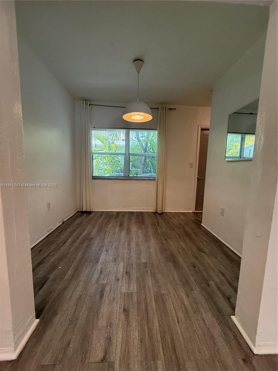 233 80th Street, Unit 1 Miami Beach, FL 33141 - Photo 5 of 24 an empty room with wooden floor and windows