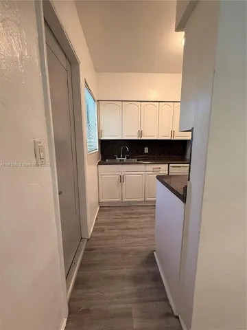 a kitchen with granite countertop a sink and cabinets