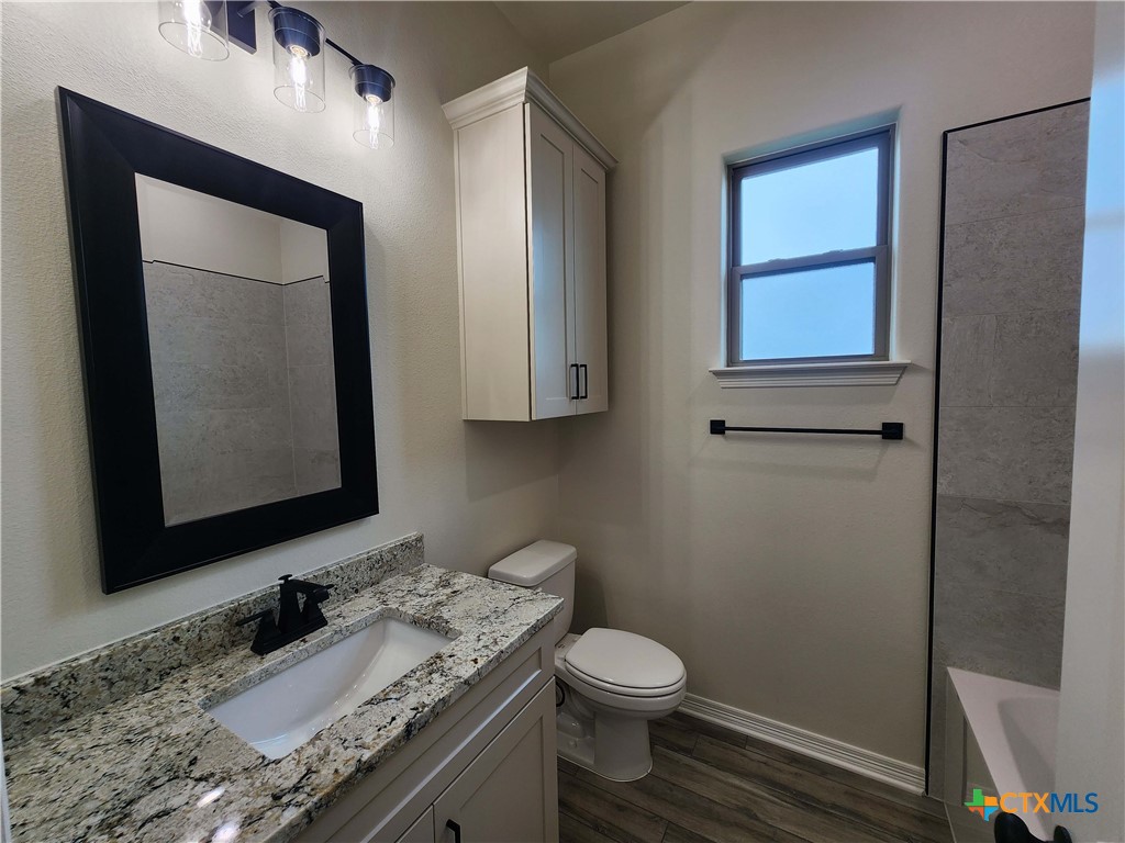 406 Talon Loop Salado, TX 76571 - Photo 14 of 31 a bathroom with a granite countertop toilet sink and mirror