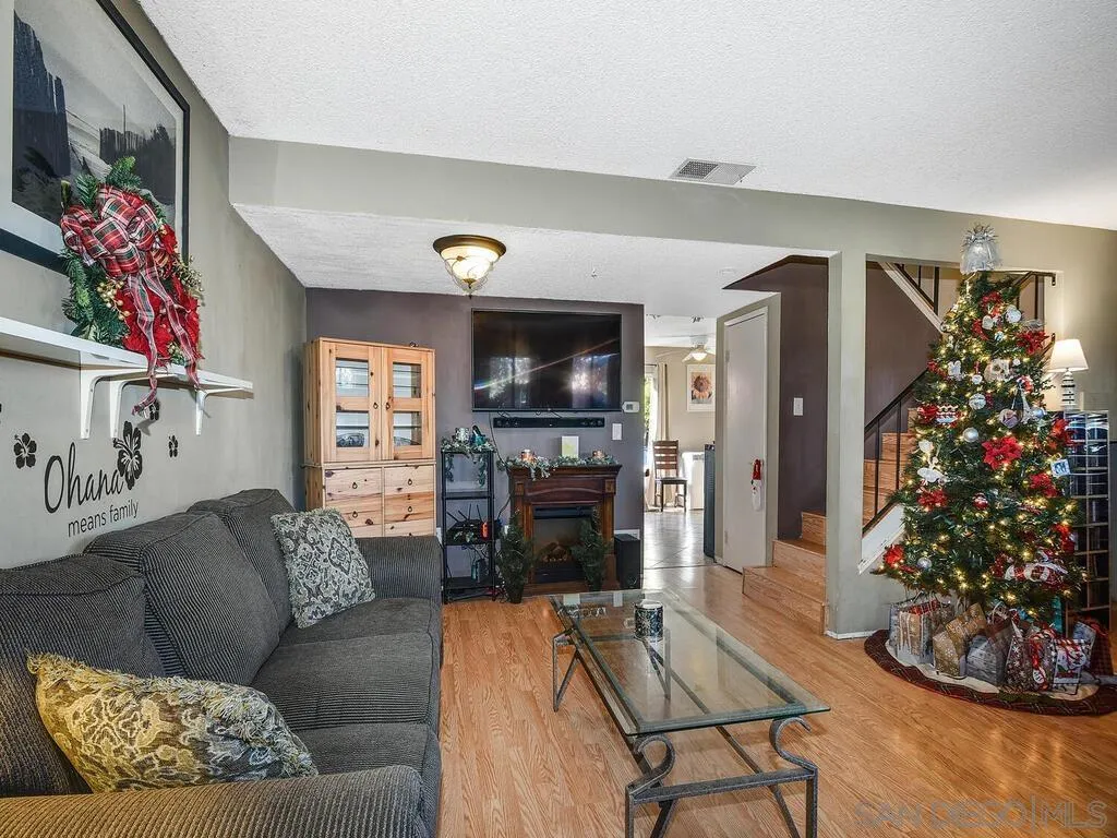 8022 Winter Gardens Boulevard, Unit E El Cajon, CA 92021 - Photo 1 of 30 a living room with furniture flat screen tv and a fireplace